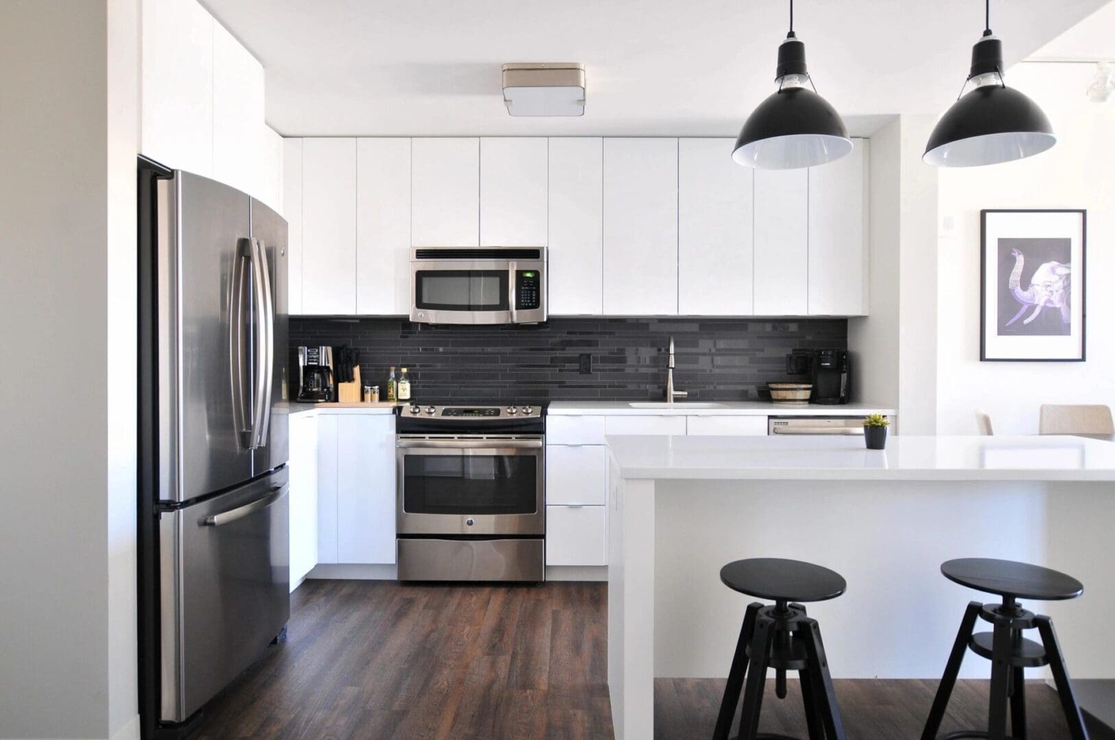 A kitchen with white cabinets and black appliances.
